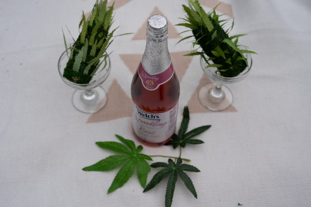 DecoBudz faux cannabis leaf used in an elegant table setting for a wedding, paired with champagne for a unique and stylish decor touch.